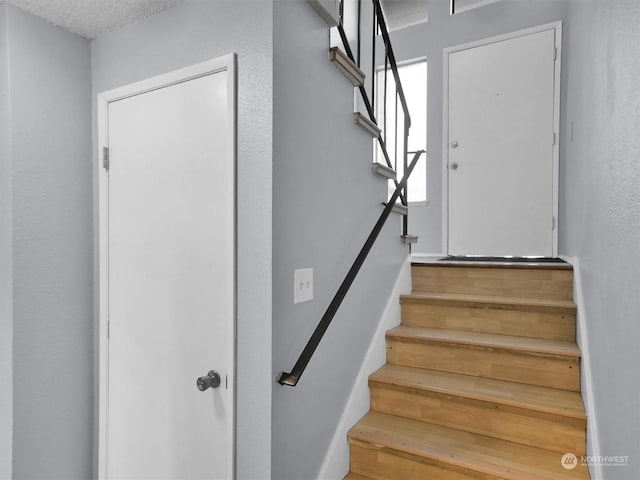 stairs featuring a textured ceiling