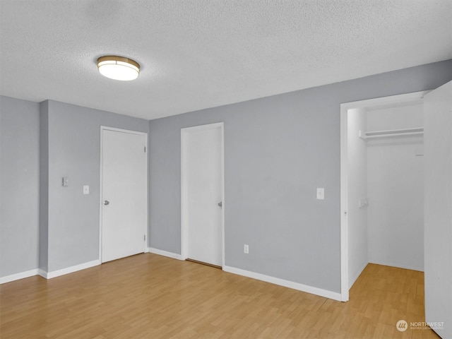 interior space with a textured ceiling and hardwood / wood-style flooring