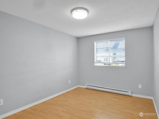 unfurnished room with wood-type flooring, a textured ceiling, and a baseboard heating unit