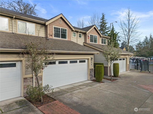 view of front of property featuring a shingled roof, fence, a garage, stone siding, and driveway