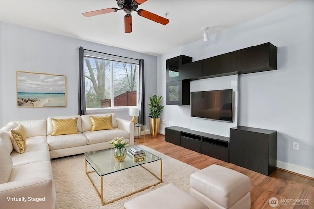 living room with a ceiling fan, wood finished floors, and baseboards