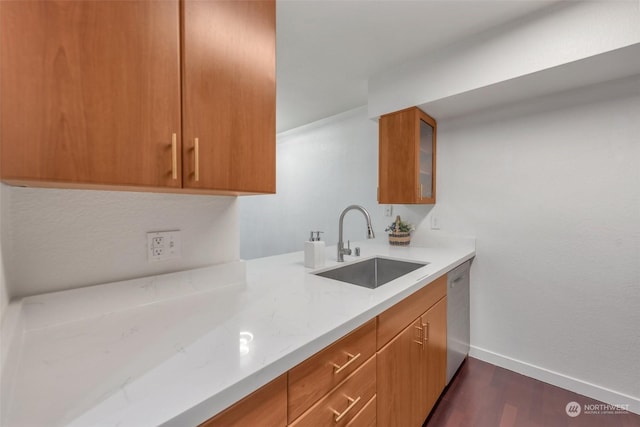 kitchen featuring light stone counters, dark wood-type flooring, dishwasher, and sink