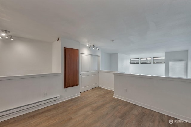 empty room with wood-type flooring and baseboard heating