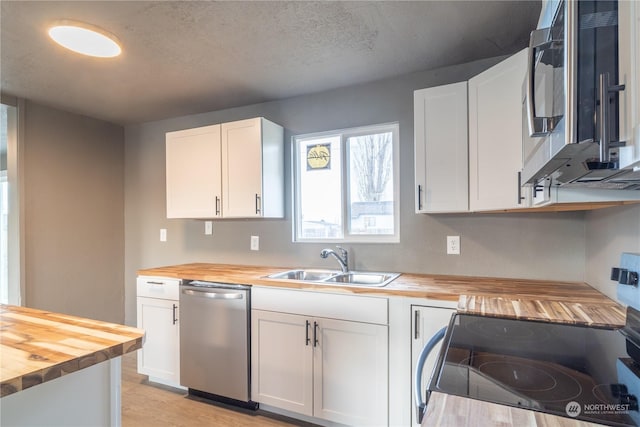 kitchen featuring white cabinets, sink, light hardwood / wood-style flooring, butcher block counters, and stainless steel appliances