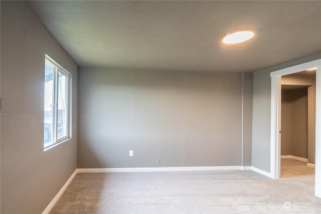 empty room featuring a textured ceiling and light carpet