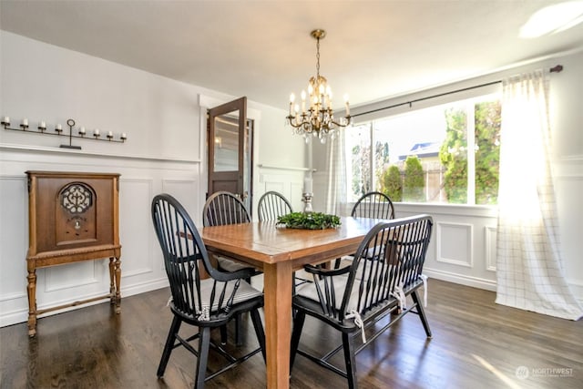 dining area with dark hardwood / wood-style flooring and an inviting chandelier