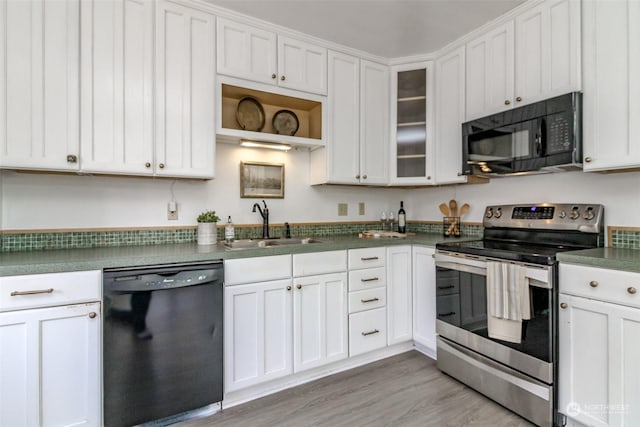 kitchen featuring white cabinets, black appliances, and light hardwood / wood-style floors