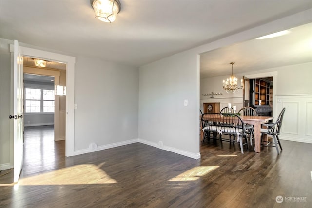 dining area featuring dark hardwood / wood-style flooring and an inviting chandelier