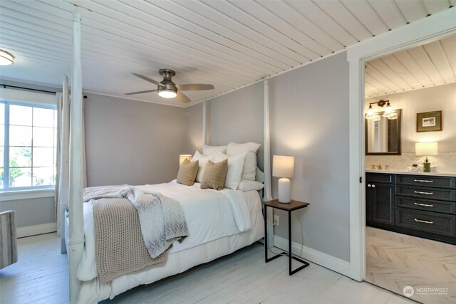 bedroom with ceiling fan, light hardwood / wood-style floors, wood ceiling, and ensuite bath