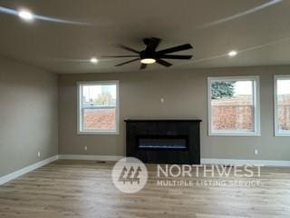 unfurnished living room with a fireplace, light wood-type flooring, and ceiling fan