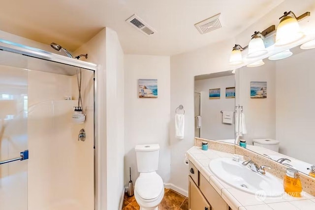 bathroom with tile patterned flooring, vanity, toilet, and walk in shower