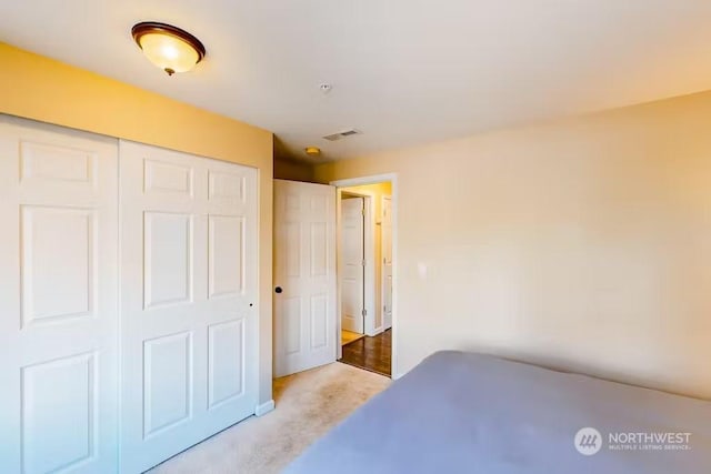 bedroom with light carpet and a closet