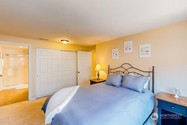 bedroom featuring light carpet, a closet, and ensuite bathroom