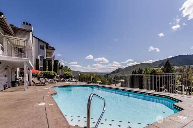 view of swimming pool with a patio area and a mountain view