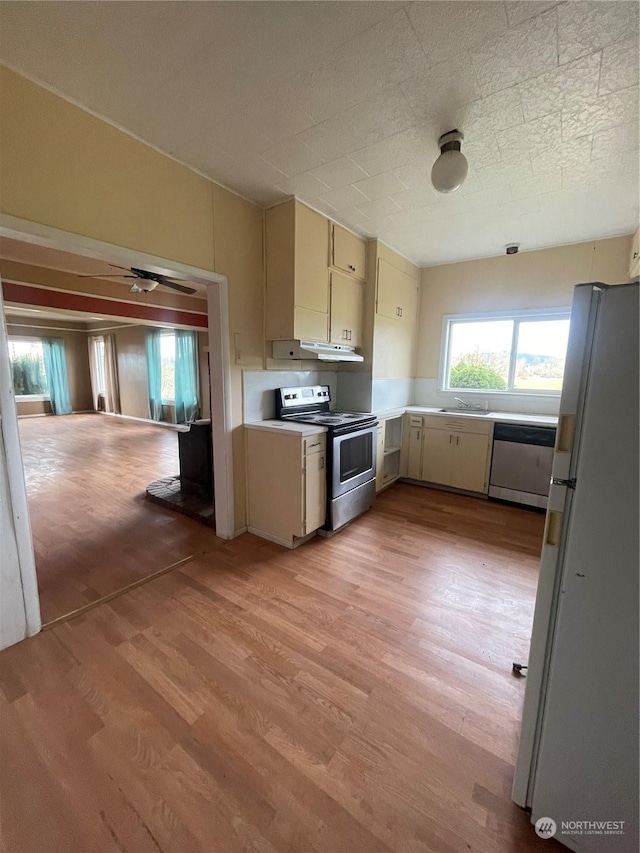 kitchen featuring appliances with stainless steel finishes, cream cabinets, and light hardwood / wood-style flooring