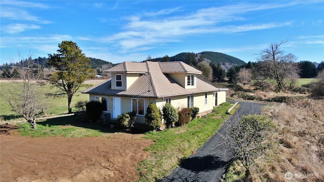 view of side of home with metal roof and a mountain view