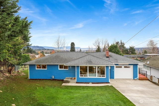 ranch-style house featuring a mountain view, a front lawn, and a garage