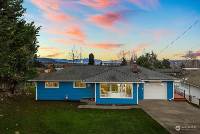 view of front of house with a lawn, a mountain view, and a garage