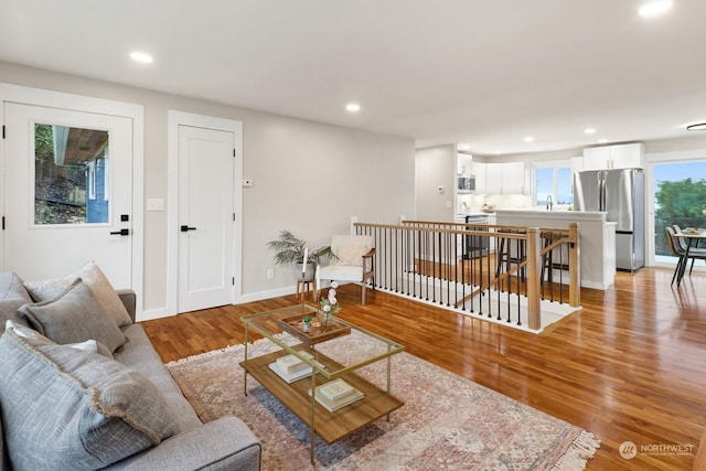 living room with light wood-type flooring and sink