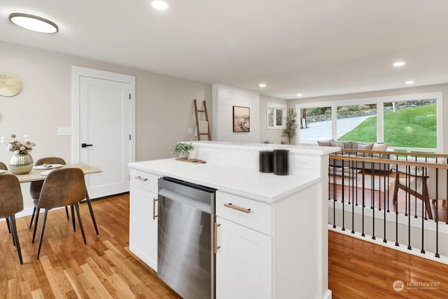 kitchen featuring white cabinetry, a center island, and light wood-type flooring