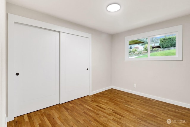 unfurnished bedroom featuring a closet and hardwood / wood-style floors