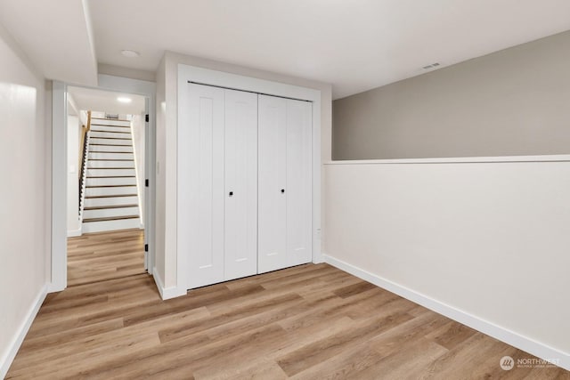 unfurnished bedroom featuring a closet and light hardwood / wood-style flooring