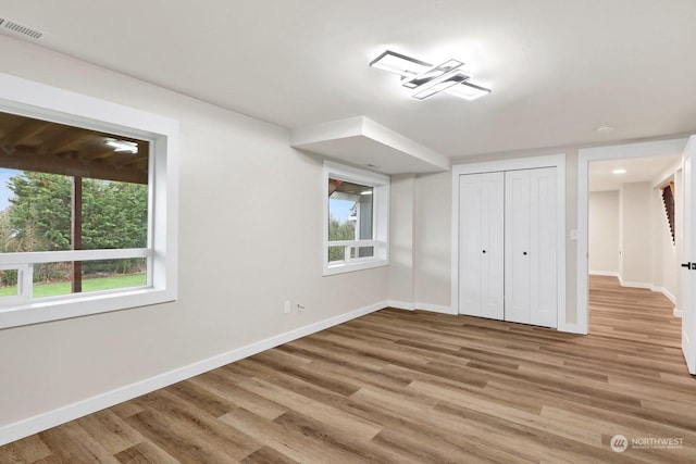 unfurnished bedroom featuring light hardwood / wood-style floors and a closet