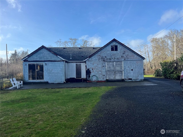 rear view of house featuring a yard