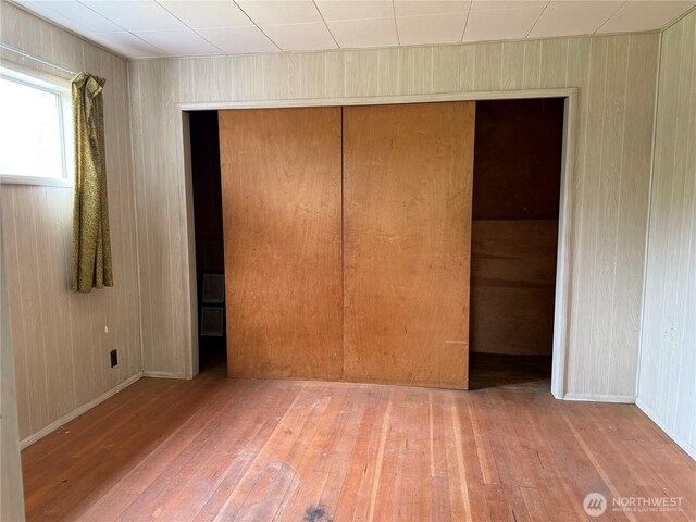 2978 Alexson Rd, North Cove, WA 98547 - unfurnished bedroom with wood-type flooring, a closet, and wood walls