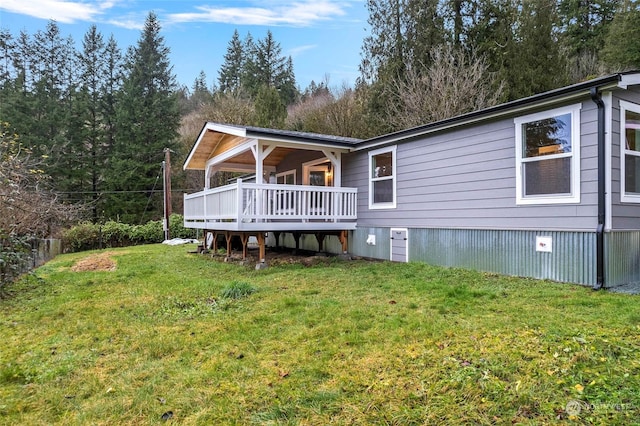 back of house with a deck and a yard