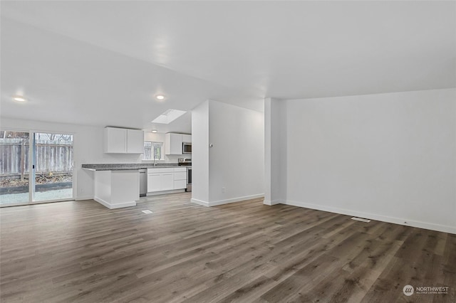 unfurnished living room featuring dark hardwood / wood-style floors and sink