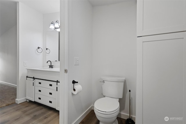 bathroom featuring vanity, hardwood / wood-style flooring, and toilet