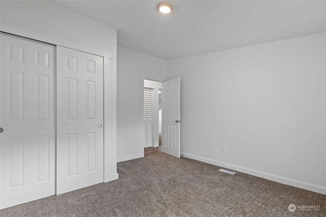 unfurnished bedroom featuring carpet and a closet