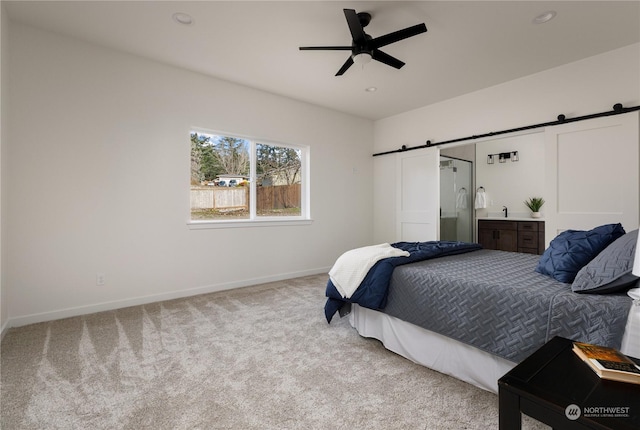 bedroom with light carpet, a barn door, and ceiling fan