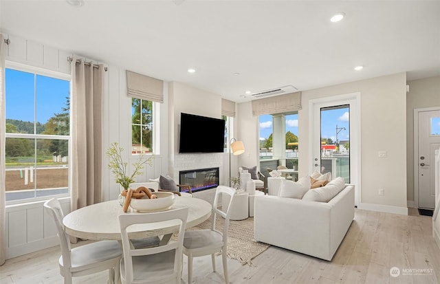 living room with light hardwood / wood-style floors and a healthy amount of sunlight