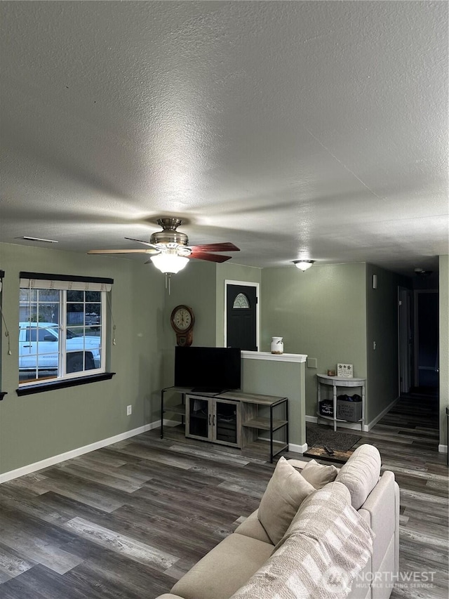 living room with ceiling fan, dark hardwood / wood-style floors, and a textured ceiling