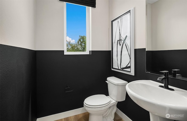 bathroom with hardwood / wood-style flooring, toilet, and sink