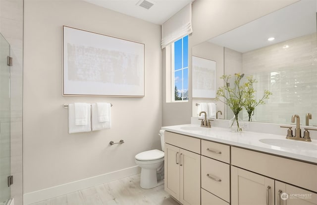 bathroom featuring hardwood / wood-style flooring, vanity, toilet, and a shower with door