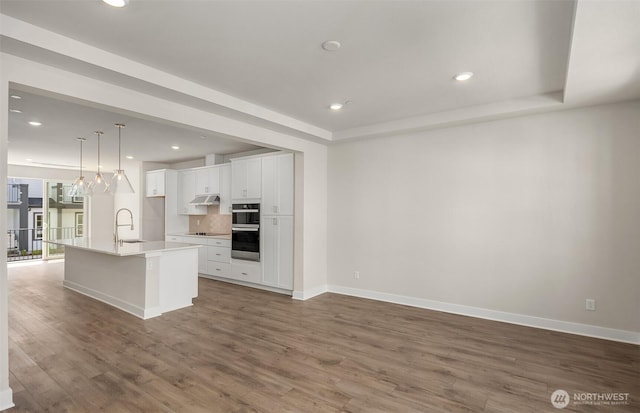 9014 NE 203rd Ln Unit C, Bothell, WA 98011 - kitchen with a sink, white cabinetry, wood finished floors, baseboards, and recessed lighting