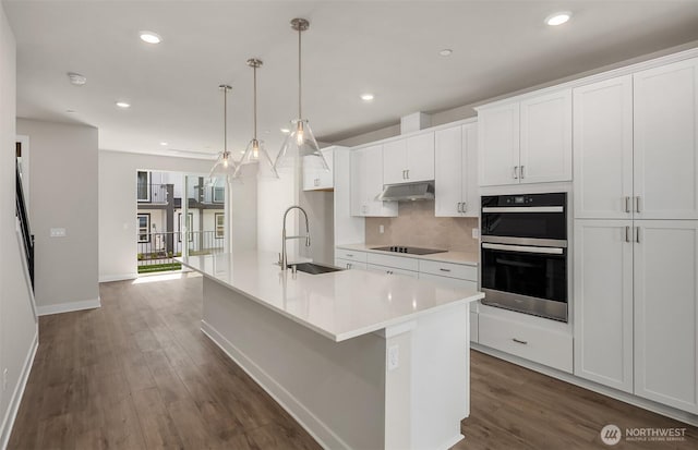 9014 NE 203rd Ln Unit C, Bothell, WA 98011 - kitchen with a sink, black electric stovetop, a kitchen island with sink, dark wood-type flooring, and multiple ovens