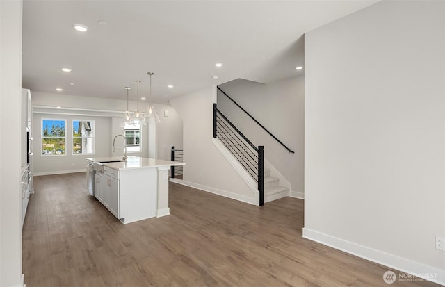9014 NE 203rd Ln Unit C, Bothell, WA 98011 - kitchen featuring a sink, white cabinetry, wood finished floors, a kitchen island with sink, and light countertops