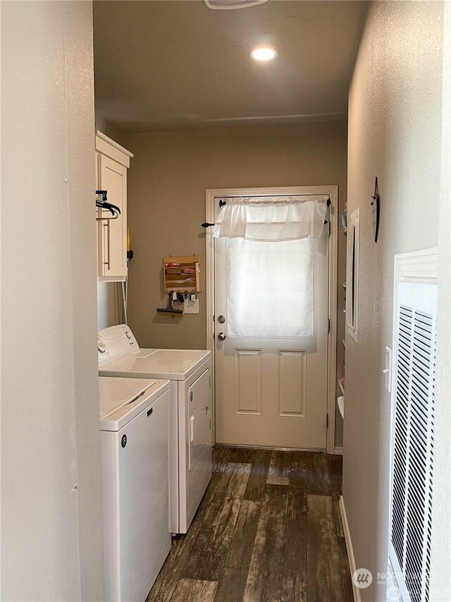 laundry room with cabinets, washer and clothes dryer, and dark wood-type flooring