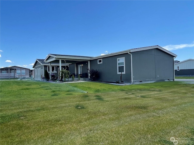 rear view of house featuring a lawn