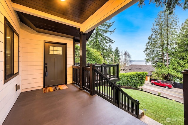 property entrance featuring a lawn and covered porch