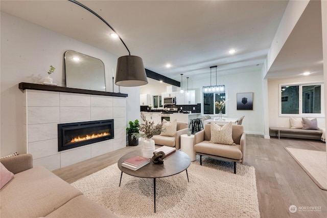 living room with light hardwood / wood-style flooring and a tiled fireplace