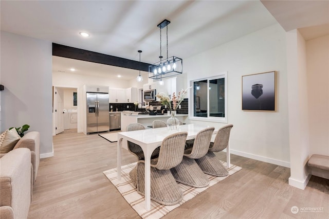 dining room with beamed ceiling and light wood-type flooring