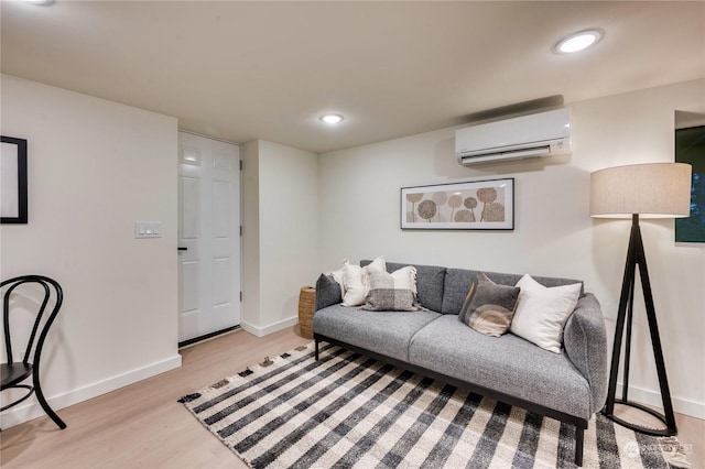 living room featuring a wall mounted air conditioner and light hardwood / wood-style flooring