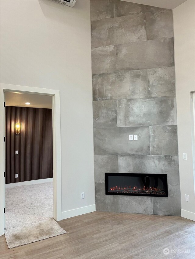 details featuring a tiled fireplace and hardwood / wood-style flooring