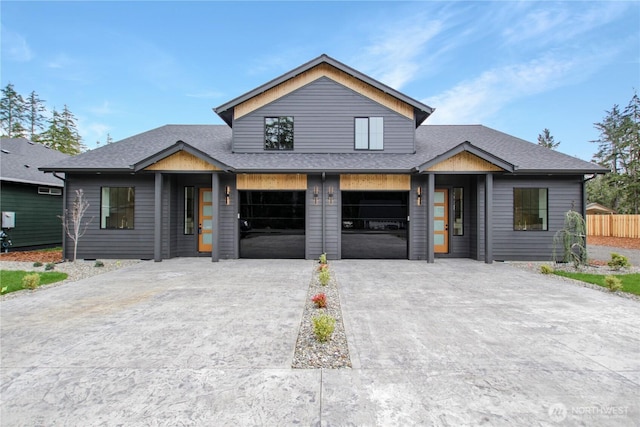 view of front of house featuring fence, an attached garage, driveway, and a shingled roof