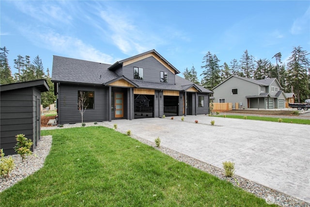 view of front of home with a front lawn, driveway, and roof with shingles